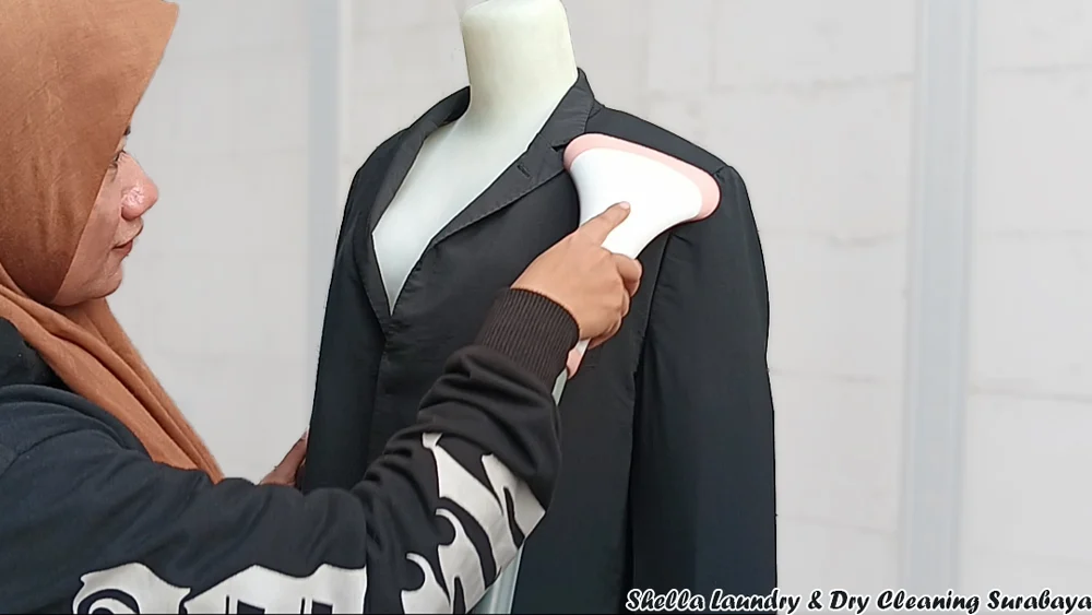 Men's and women's suits receiving professional dry cleaning at Shella Laundry Surabaya