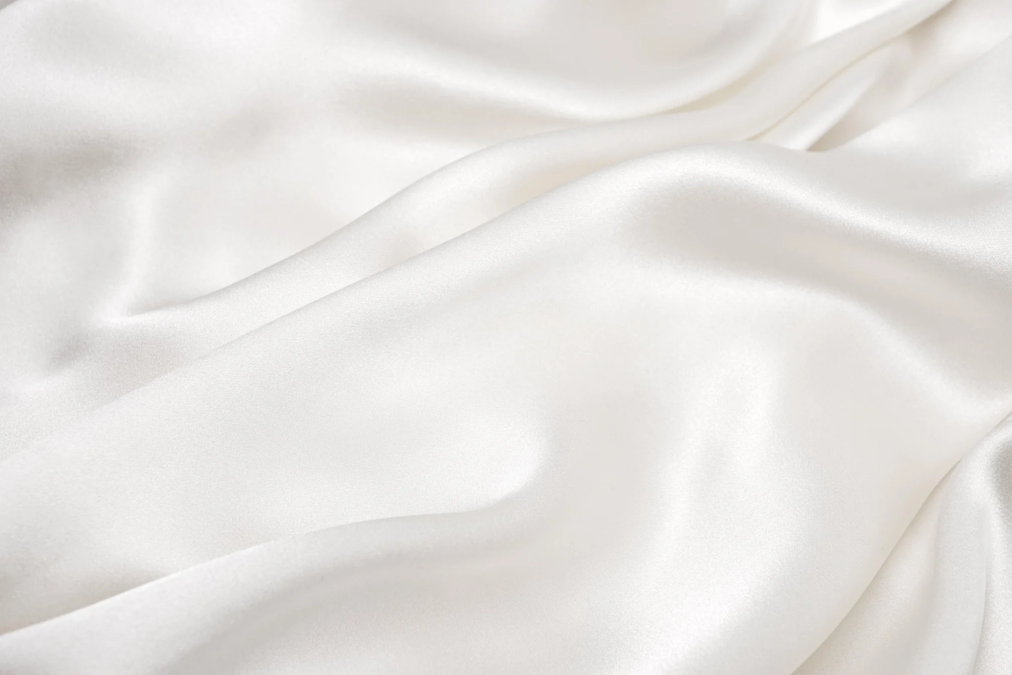 Smooth luxuriously rippled white couture silk fabric texture